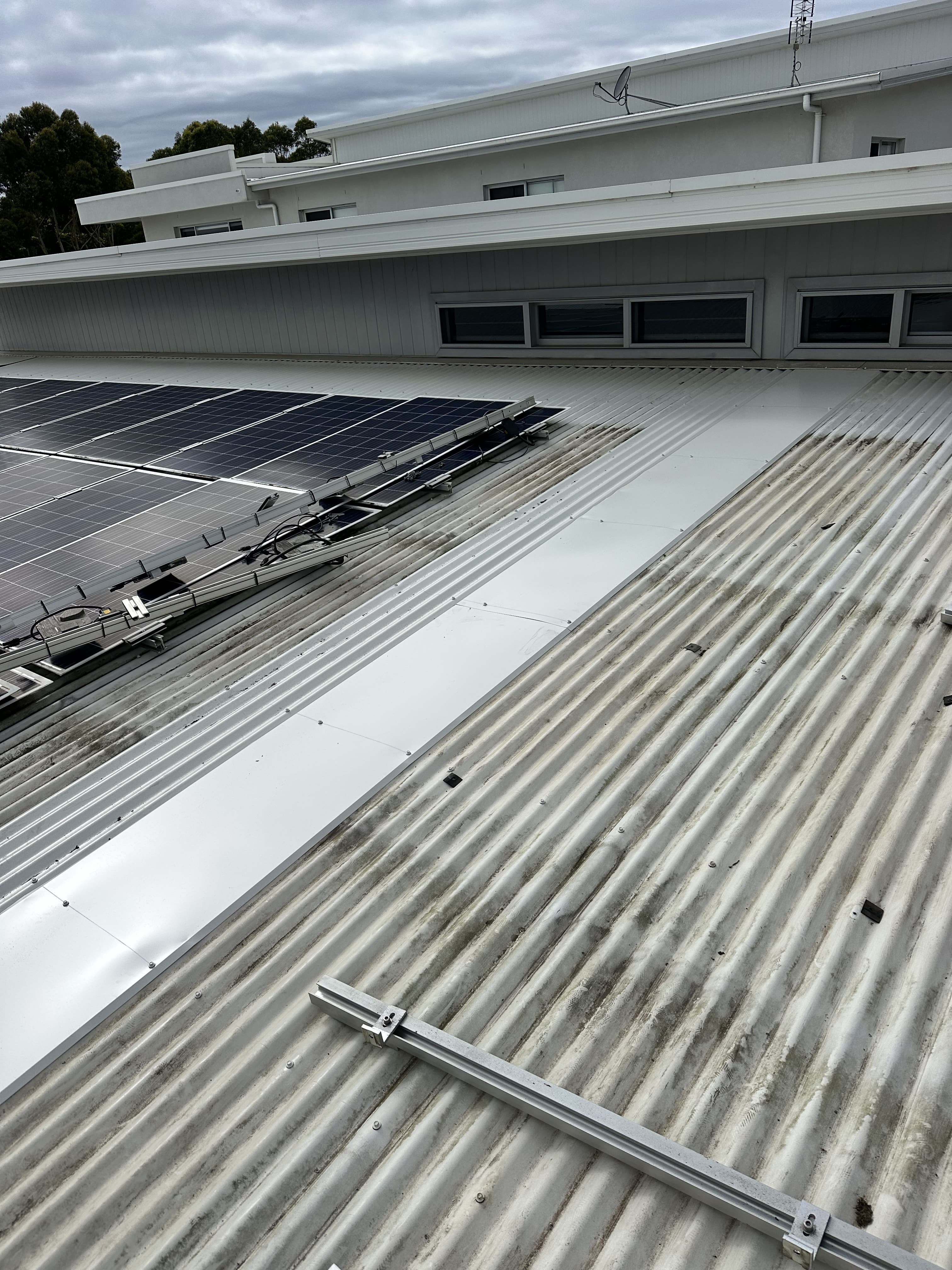 New Colorbond roof sheeting installed alongside existing roofing during a repair
